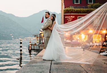 a bride and groom standing on a pier in Malcesine