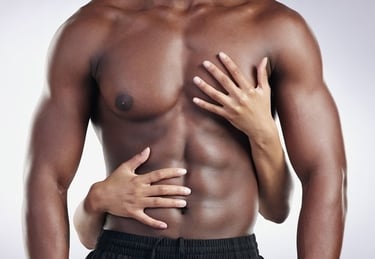 Close up of a muscular man's toned abs and chest with hands touching his torso.