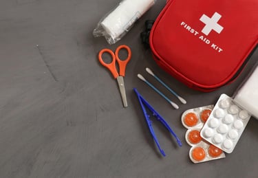 First aid kit and survival tools on table, showing emergency preparedness and wilderness safety