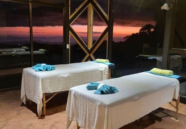 two massage beds in a room with a view of the ocean