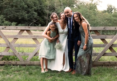 famille devant une clôture en bois qui pose pour une photo de mariage