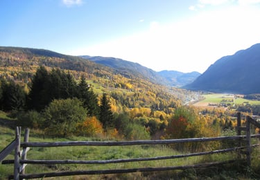 A wooden fence with mountains and a valley in the distance