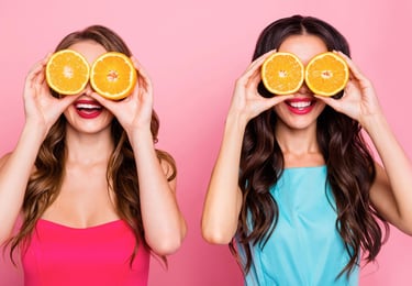 Logo de Subjetive y al lado una imagen de dos chicas felices y sonrientes con naranjas en los ojos.