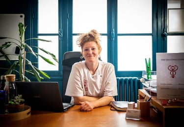 Photo couleur d'une femme médecin assise à un bureau avec un ordinateur portable