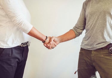 Begrüßungsbild mit zwei Personen die sich die Hände reichen