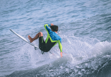 a man in a wetsuit surfing on a surfboard