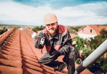 roofing worker smiling for the camera on an orange roof