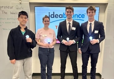 a group of four people holding lightbulbs in front of an ideabounce sign
