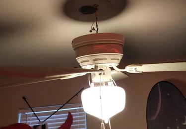 a ceiling fan with a light fixture on top of a ceiling fan