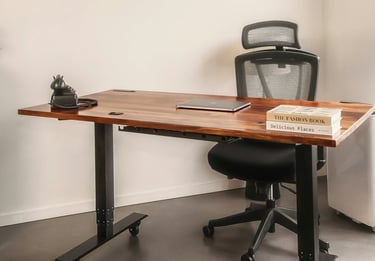 A chair behind a desk with a closed laptop, books, and old-style phone.