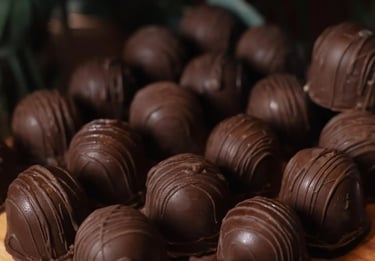 Uma deliciosa seleção de bombons de chocolate dispostos em uma superfície de madeira, destacando a f
