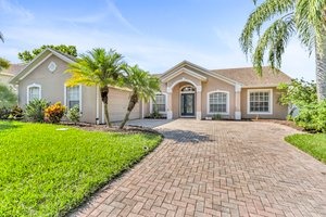 a house with a brick exterior and palm trees