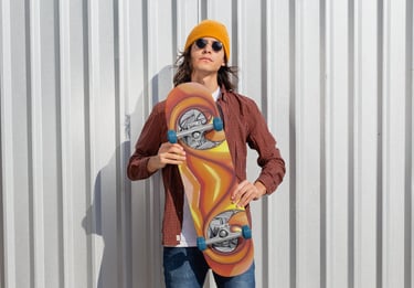 a man in a yellow hat and sunglasses holding a skateboard