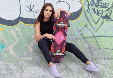 a woman sitting on a skateboard in a skateboard park