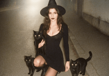 Une sorcière entourée des ses chats noirs pour la journée internationale du chat noir.