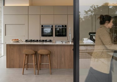 Cuisine sur mesure avec îlot central en bois et façades beige conçue par cuisiniste à Caen
