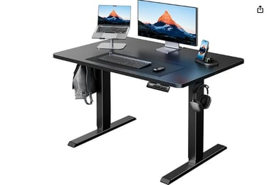 a computer desk with a monitor, keyboard, and a laptop