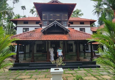 Front view of Poomuttath Illam, an aristocratic Kerala heritage home, framed by lush gardens