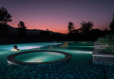 Person relaxing in a pool at Agraharam with serene surroundings.