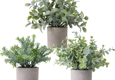 Set of three small artificial potted plants in grey concrete pots for home office decor.