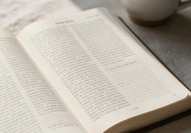 An open Bible on a clean linen surface next to a simple ceramic cup, soft morning light casting gentle shadows across the pages.
