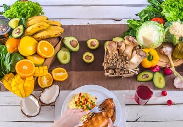 Mesa repleta de alimentos saudáveis como frutas, legumes, verduras e cogumelos.