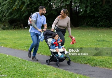 a man and woman walking with a baby in a stroller