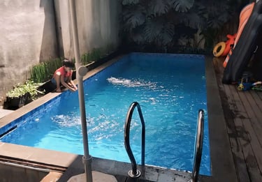 Suasana malam kolam renang air hangat di villa Bekasi, lampu menyala.