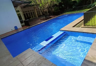 Kolam renang air hangat minimalis dengan dek kayu di halaman belakang rumah Karawang