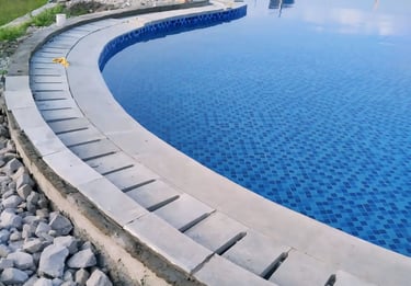 Kolam renang umum berbentuk lingkaran dengan keramik roman berwarna biru.
