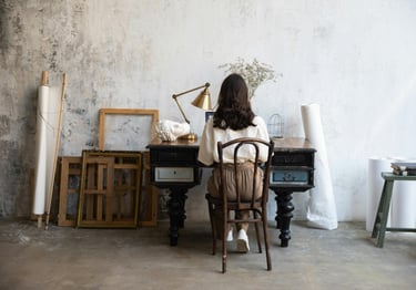 Mulher sentada à escrivaninha (Visão de costas)