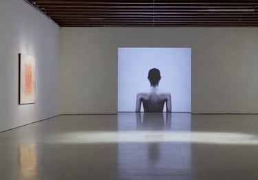 Sala de galeria minimalista com uma projeção em tela grande