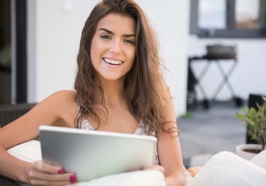 a woman sitting on a couch with a tablet computer