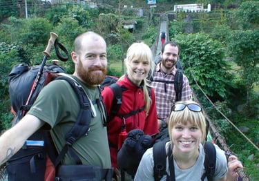 four trekkers on a bridge on the Annapurna Circuit trek.