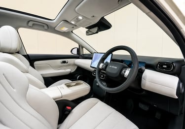 Interior do GAC Aion UT com bancos claros, teto panorâmico e painel multimídia moderno