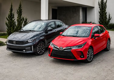 Toyota Yaris vermelho e Fiat Cronos cinza lado a lado sem placas dianteiras.