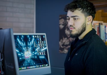 a man in a black shirt is looking at a computer screen
