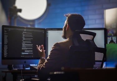 Zues Ordaz sitting at desk with two monitors
