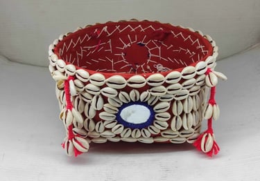 "Decorative bamboo basket wrapped in red fabric with shell embellishments and floral garland–Meant for export"