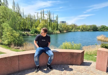 a man sitting on a bench in front of a lake