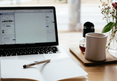 a laptop computer and a pen on a desk