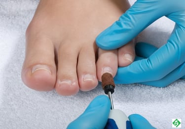 Professional podiatrist using an electric nail drill to perform a medical pedicure on a patient's toenails.