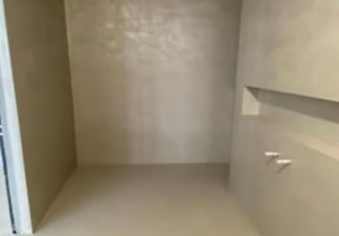 Beige microcement finish without joints on the walls and floor.