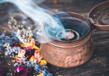 “Pot en cuivre dégageant de la fumée d’encens avec des fleurs séchées pour une purification spiritue