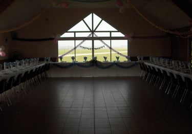 une salle de réception sombre avec des fenêtres au milieu