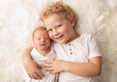 a baby and his brother are posing for a photo