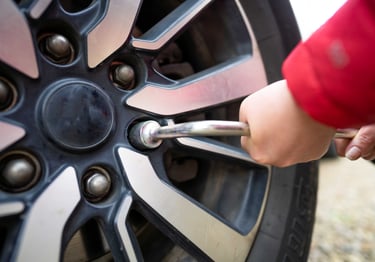 a person tightening a wheel nut of a tire