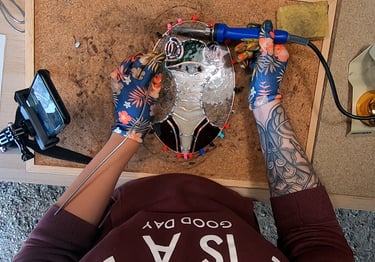 a person who is soldering a sun catcher, stainglass