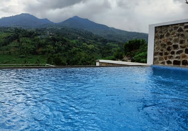 Kolam infinity di tebing dengan pemandangan laut lepas.