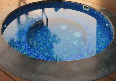 Jakuzzi berbentuk lingkaran dengan keramik roman berwarna biru.